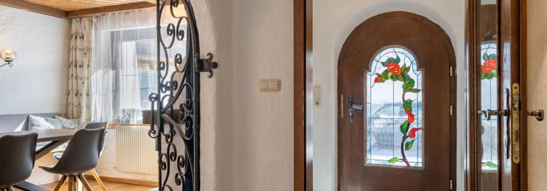 An inviting entrance area with a beautiful steel gate and a colorful glass door. The interiors are bright and friendly with modern furniture. - Garni Nadine - Sölden