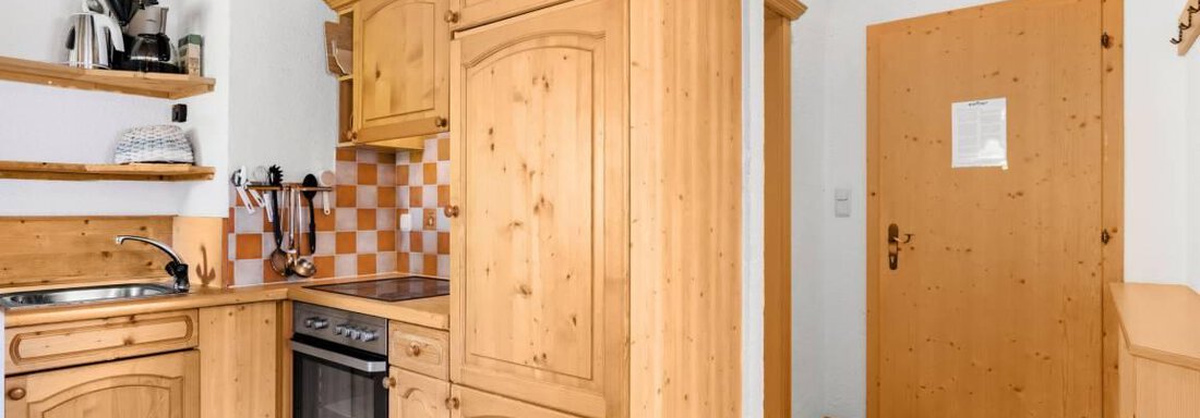 Nederkogl A cozy kitchen with wooden furniture and modern kitchen equipment. The floor is made of wood and the walls are bright. - Garni Nadine - Sölden