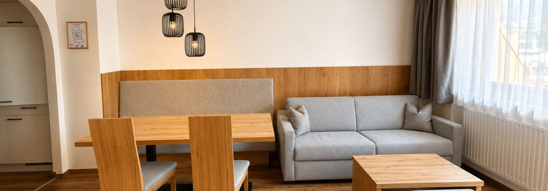 image A modern living room with a cozy sofa, a table, and wooden chairs.
Large windows let in plenty of light and create an inviting atmosphere. - Gästehaus Europa - Sölden