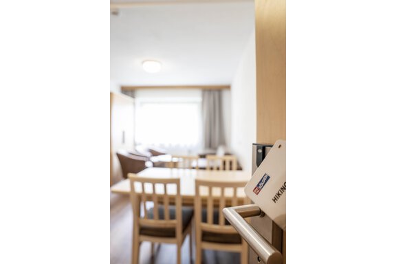 An inviting room with a cozy table and chairs. Natural light can be seen through the window, creating a pleasant atmosphere. - Gästehaus Europa - Sölden