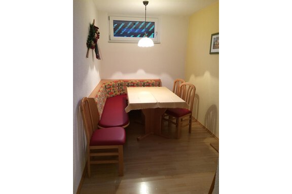 Sitzecke A small dining area with a bench and chairs. The table is centrally placed and there is a window that lets light in. - Gästehaus Martin - Sölden