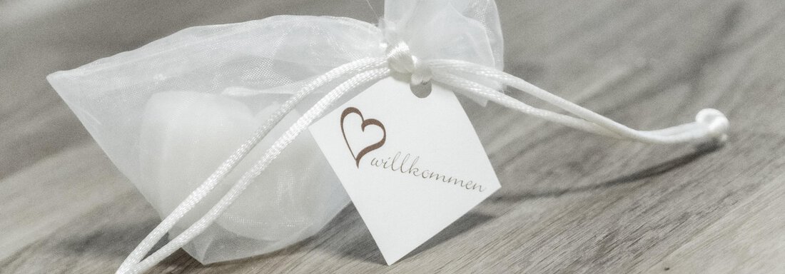 A white organza bag with a small card. The bag seems to be a gift or a special surprise. - Gästeheim Schmiedhof - Sölden