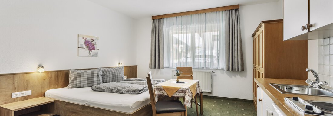 _F0A8297 A cozy room with a double bed and a small kitchenette. The space is bright and friendly with a table and chairs, as well as a window that lets in natural light. - Gasthof Granstein - Sölden