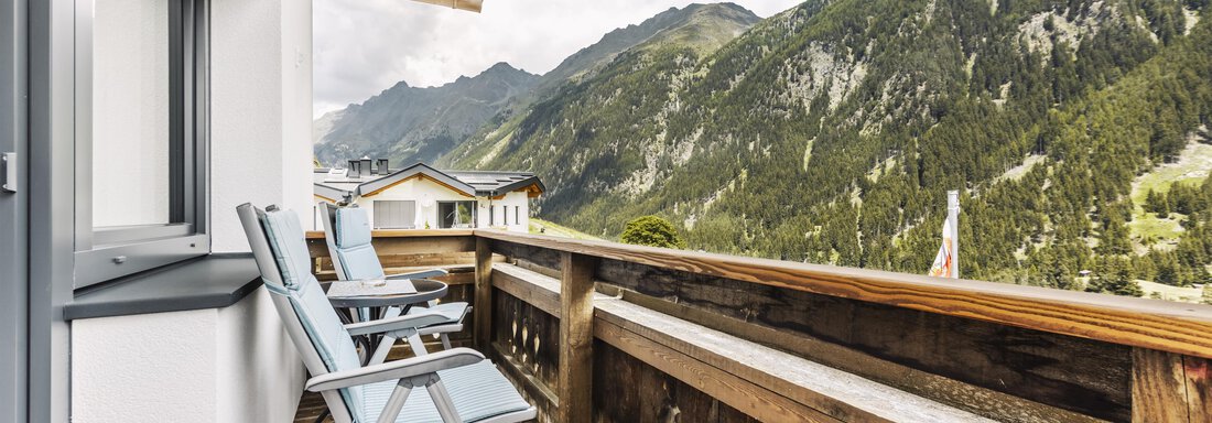 A balcony with two lounge chairs and a view of the high mountains. The atmosphere is calm and inviting. - Gasthof Granstein - Sölden