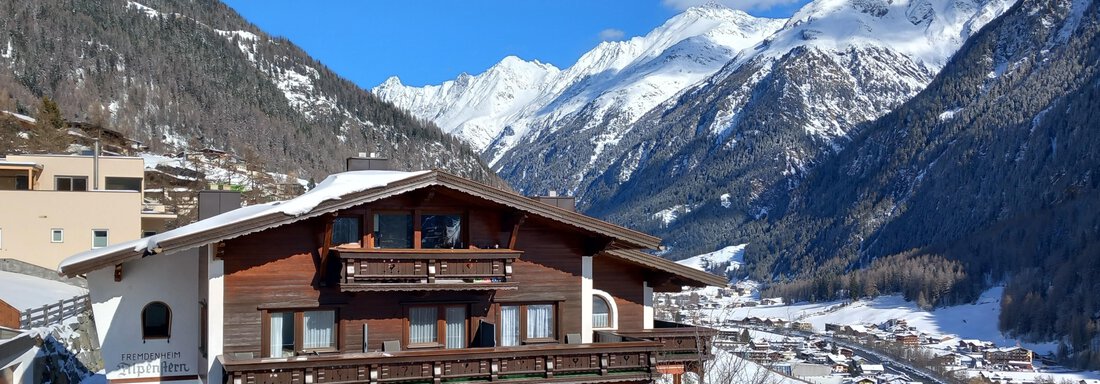 A traditional alpine hut surrounded by snow-covered mountains. The sky is clear and the landscape features a picturesque view of the valley. - Haus Alpenstern - Sölden