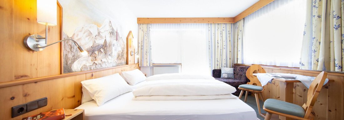 Appt. 2 Schlafzimmer I A bright, cozy room with two beds and wooden paneling. The large windows provide plenty of daylight and an inviting atmosphere. - Haus Alpenstern - Sölden