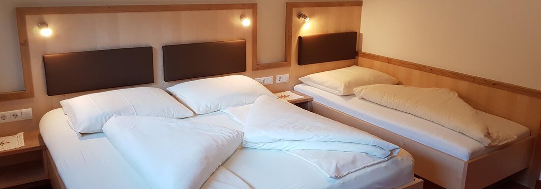 A cozy hotel room with two beds. The walls are light, and there is pleasant lighting. - Haus Christian - Sölden