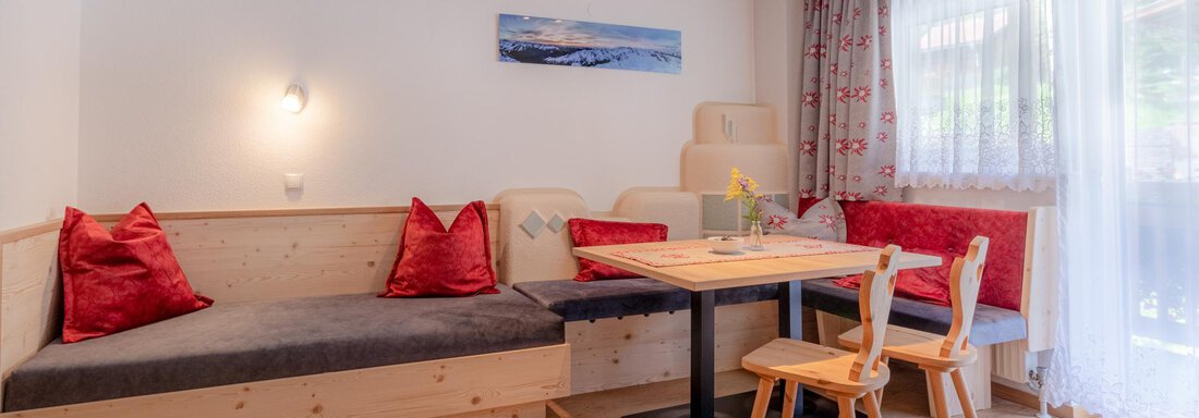 Edelweiß Wohn-Schlafraum Haus Edmund A cozy living area with a seating area and a dining table. The bright windows let in a lot of light and create an inviting atmosphere. - Haus Edmund - Sölden