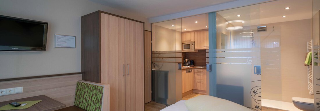Kristall A modern room with a double bed, a television, and a small kitchenette. The room is bright and pleasantly furnished. - Haus Fridolin - Sölden