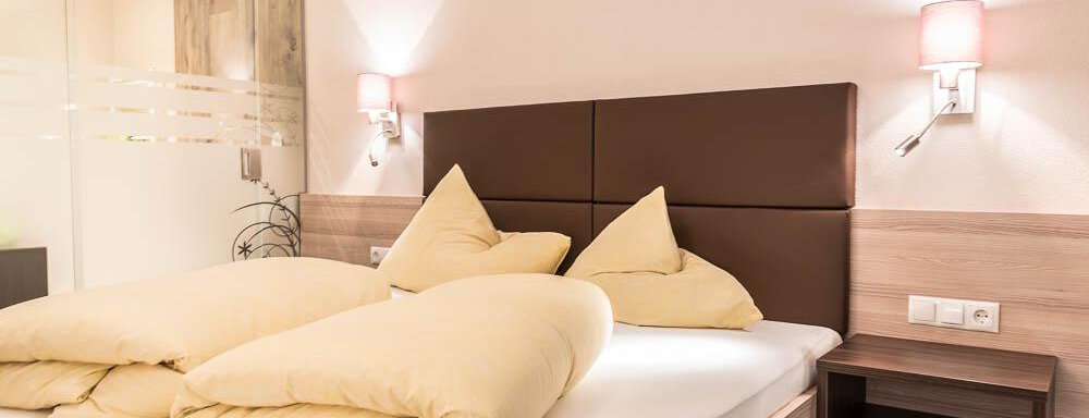 A cozy bedroom with a large bed and soft pillows. The walls are painted in neutral colors and there is gentle lighting. - Haus Fridolin - Sölden