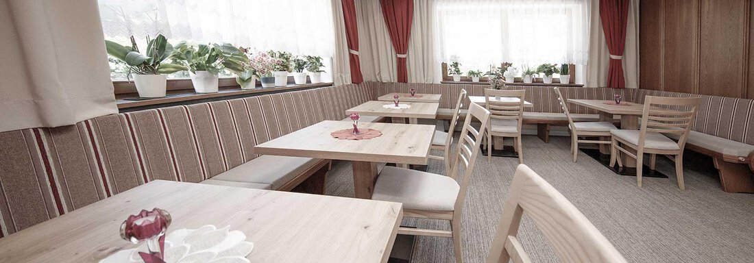 A cozy restaurant with wooden furniture and large windows. The tables are simply decorated and the room has an inviting atmosphere. - Haus Gabriela - Sölden