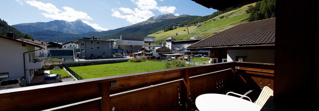 A beautiful view from a balcony overlooking the green valley and the mountains in the background. The sky is clear and blue, with some clouds. - Haus Gabriela - Sölden