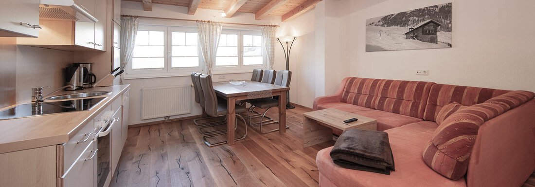 A cozy vacation apartment with a modern kitchen and a large dining area. The wood decor creates a warm atmosphere. - Haus Gondelblick - Sölden