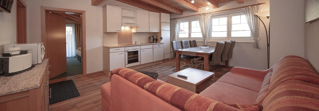 A cozy apartment with wooden ceilings and modern furniture. The open living/dining area is bright and inviting. - Haus Gondelblick - Sölden