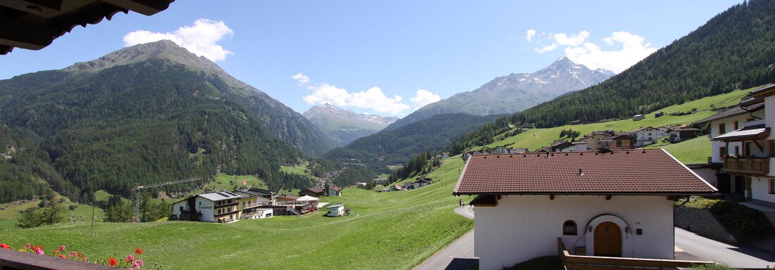 A picturesque landscape with green meadows and majestic mountains. In the foreground, a typical Alpine house can be seen. - Haus Montjola - Sölden