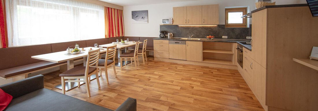 A bright and modern apartment with wooden flooring and an open living area. The kitchen is well-equipped, and the dining area accommodates several people. - Haus Montjola - Sölden