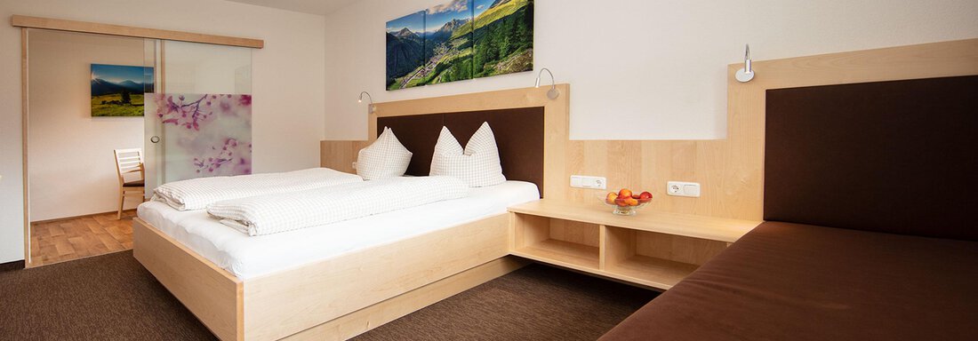 A modern hotel room with two beds and a cozy decor. A landscape picture hangs on the wall and there is pleasant lighting. - Haus Montjola - Sölden