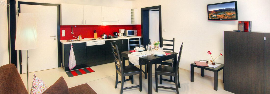 A modern kitchen with a dining area and a cozy living room. Bright colors and a friendly atmosphere characterize the space. - Haus PIA by A CASA - Sölden