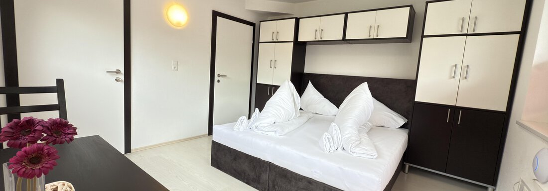 A modern bedroom with a double bed and elegant furnishings. The room is bright and friendly, with a table and chairs. - Haus PIA by A CASA - Sölden