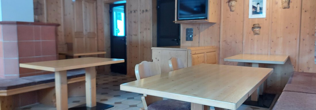A cozy interior with wooden furniture and fluffy seating. The walls are made of wood, and there is pleasant lighting. - Haus Pitzwald - Sölden
