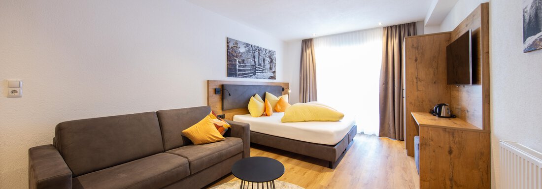 Suite 19-1 A modern room with a double bed and a cozy sofa. The space is bright and inviting, with a round table in the middle. - Haus Stefanie - Sölden