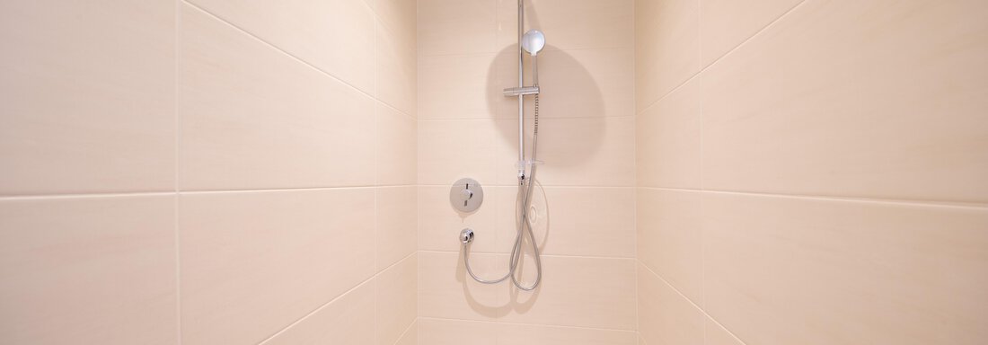 A modern shower cubicle with bright tiles. The shower is equipped with a modern showerhead. - Haus Stefanie - Sölden
