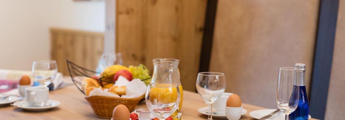 A laid breakfast table with eggs, fruit, and drinks. The atmosphere feels inviting and cozy. - Haus Stefanie - Sölden