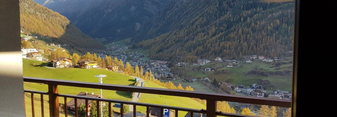 An impressive mountain landscape with green meadows and small houses in the valley. The mountains are majestic and partially covered with clouds. - Haus Stefanie - Sölden