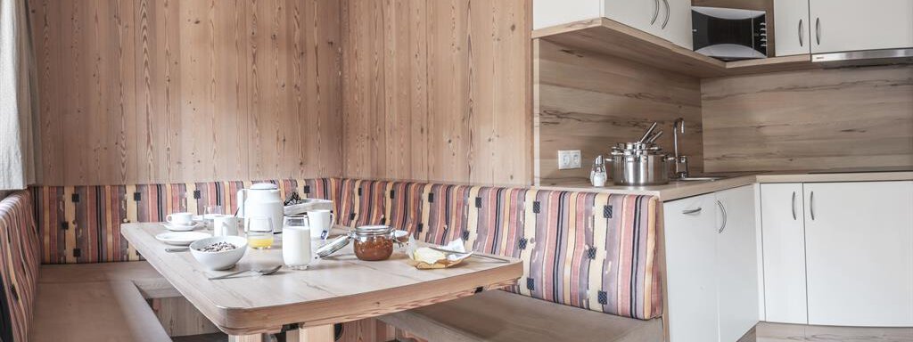 Wohnküche A modern kitchen with a cozy dining area. The table is set with dishes and breakfast items. - Haus Tanja - Sölden