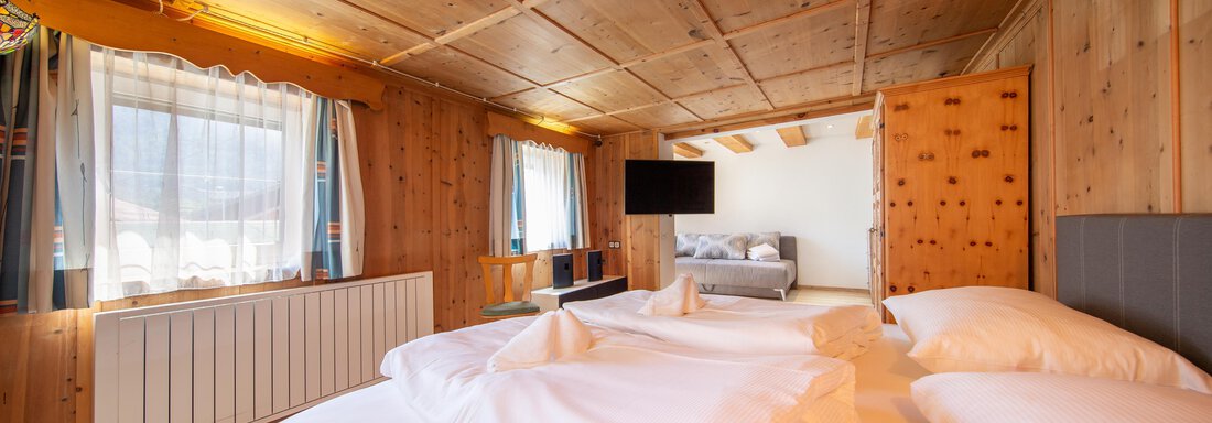 A cozy room with bright wooden walls and large windows. There is a double bed and a pleasant atmosphere. - Haus Valtelas - Sölden
