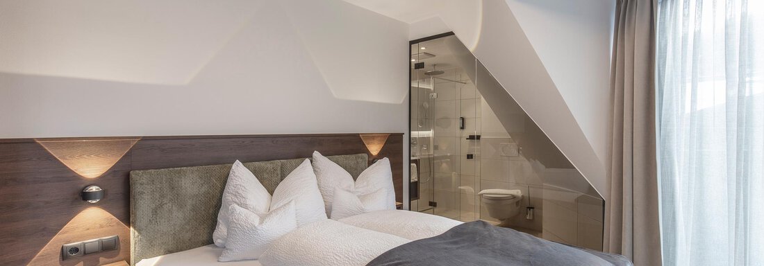 A modern bedroom with a cozy double bed and large windows. The decor is bright and inviting, perfect for relaxation. - Home4You - Sölden