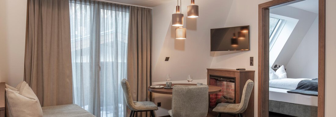 A modern room with a dining area, a sofa, and large windows. The atmosphere is bright and inviting. - Home4You - Sölden
