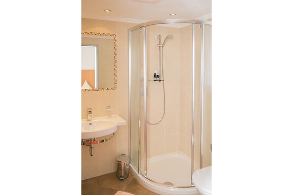A bright shower in a modern bathroom. The room is designed with neutral colors and elegant fixtures. - Hotel Garni Ehrenreich - Sölden