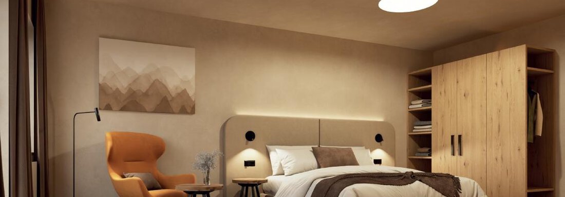 Zimmer NEU Visualisierung The image shows a modern bedroom with a large bed and a cozy armchair. The walls are painted in neutral tones, and there is a wooden wardrobe in the background. - Hotel Garni Hainbacherhof - Sölden