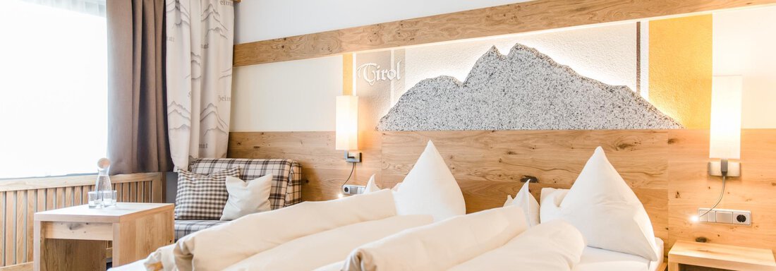 Doppelzimmer Kat A | © Sportpension Carinthia A cozy hotel room with wooden details and two beds. Large windows provide plenty of daylight and a pleasant atmosphere. - Hotel Sportpension Carinthia - Sölden