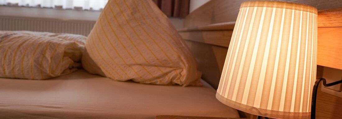 Ein gemütliches Schlafzimmer mit einem Kissen und einer warmen Lampe. Die Atmosphäre ist einladend und entspannt. - La Luna - Sölden
