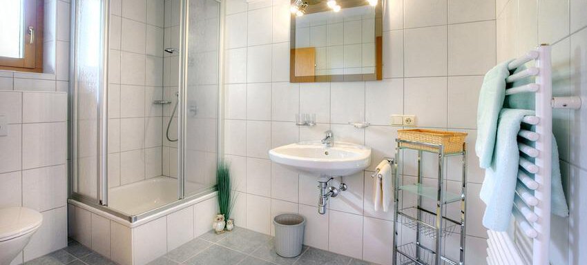 Ein modernes Badezimmer mit einer Dusche und einem Waschbecken. Die Wände sind gefliest und es gibt eine große Mirror über dem Waschbecken. - La Luna - Sölden