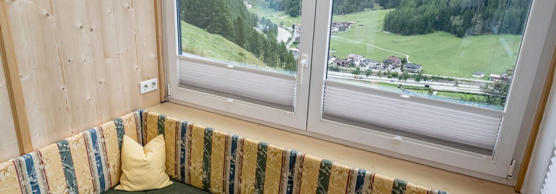 A cozy living area with a seating corner and a view of the surrounding mountains. Large windows let in plenty of light and offer a beautiful view of the landscape. - Lyns Home - Sölden