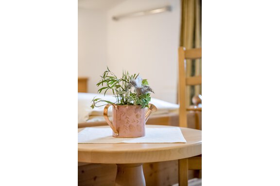 A beautiful room with a wooden table and an elegant plant in a copper kettle. The atmosphere feels cozy and inviting. - Lyns Home - Sölden