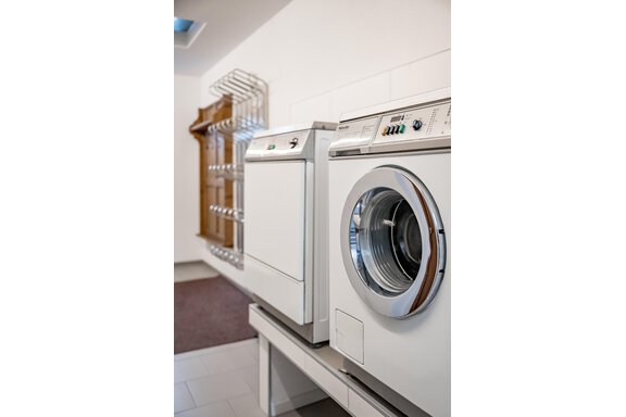 A washing machine and a dryer stand side by side in a modern laundry room. The room is bright and tidy. - Lyns Home - Sölden