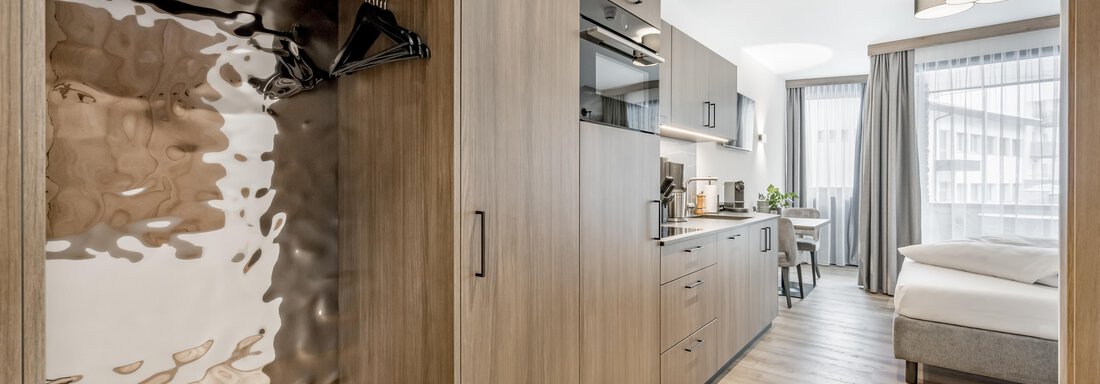 A modern accommodation with wooden shelves and a small kitchenette. The room is bright and cheerful with a window that lets in daylight. - Marco's Mountain Home - Sölden