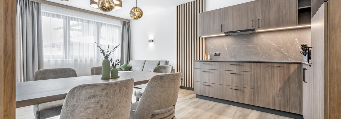 Apartment fünf'ar A modern kitchen with wooden fronts and an elegant dining table. The atmosphere is bright and inviting. - Marco's Mountain Home - Sölden