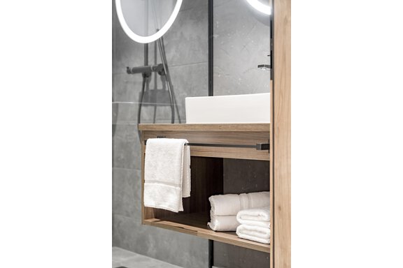 A modern bathroom with an elegant sink and a wooden shelf. White towels are neatly stored and the walls are designed in gray tones. - Marco's Mountain Home - Sölden