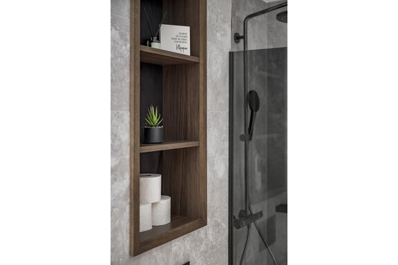 A modern bathroom area with a wooden shelving unit. Inside are plants, toilet paper rolls, and a decorative item. - Marco's Mountain Home - Sölden