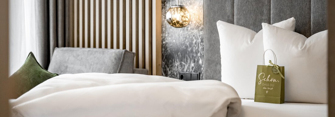 A modern bedroom with a comfortable bed and elegant pillows. In the background, there is a cozy seating area and a decorative wall mural. - Marco's Mountain Home - Sölden