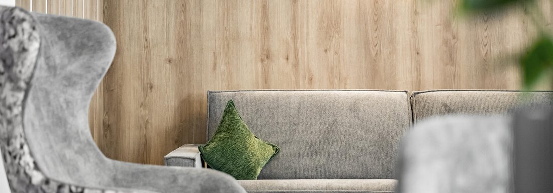 A modern living room with a gray sofa and a decorative pillow. The wooden paneling creates a warm atmosphere. - Marco's Mountain Home - Sölden