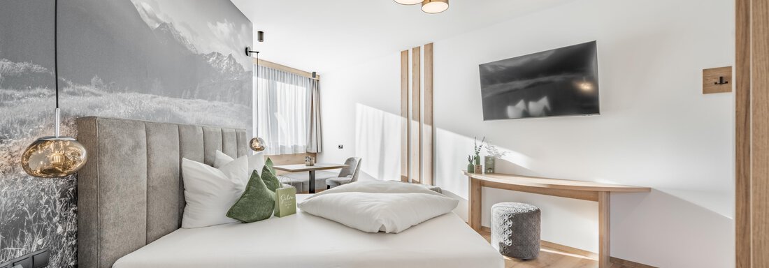 A stylish bedroom with a modern bed and a cozy design. The room is bright and inviting, with a large window and a desk. - Marco's Mountain Home - Sölden