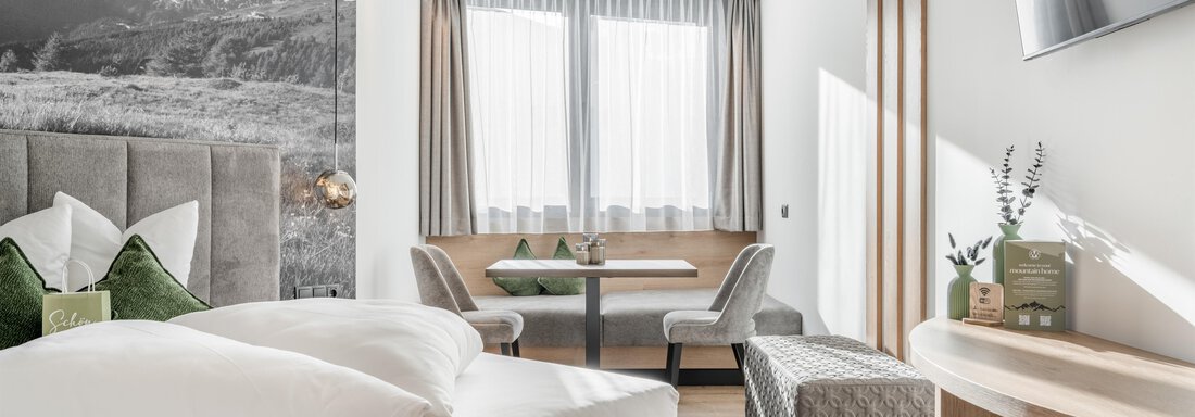 A modern room with a bed, elegant furniture, and large windows. The decor is bright and friendly, perfect for a relaxed getaway. - Marco's Mountain Home - Sölden