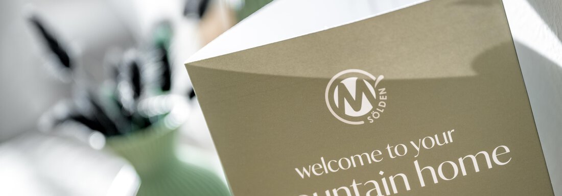 A welcome sign for your "Mountain Home". In the background, green vases and writing utensils are visible. - Marco's Mountain Home - Sölden