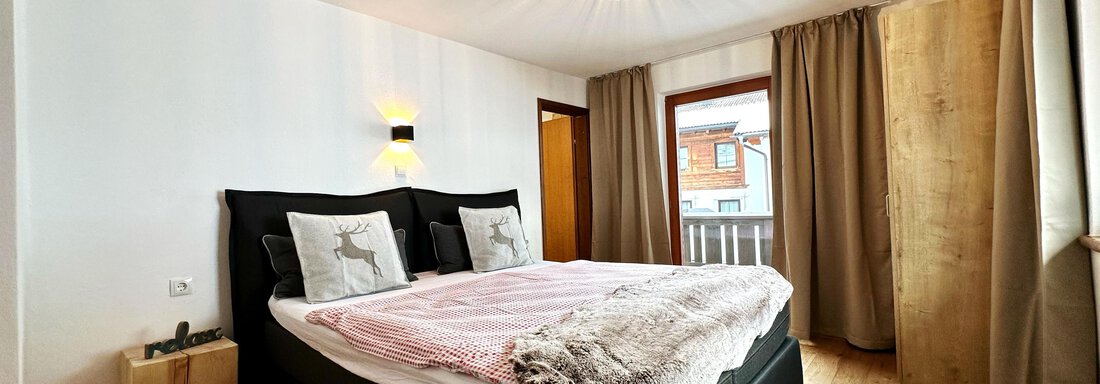 one of 7 bedrooms A cozy bedroom with modern furniture and a large bed. The large windows let in plenty of daylight and the wooden floor creates a warm atmosphere. - Mountain Lodge Sölden - Sölden